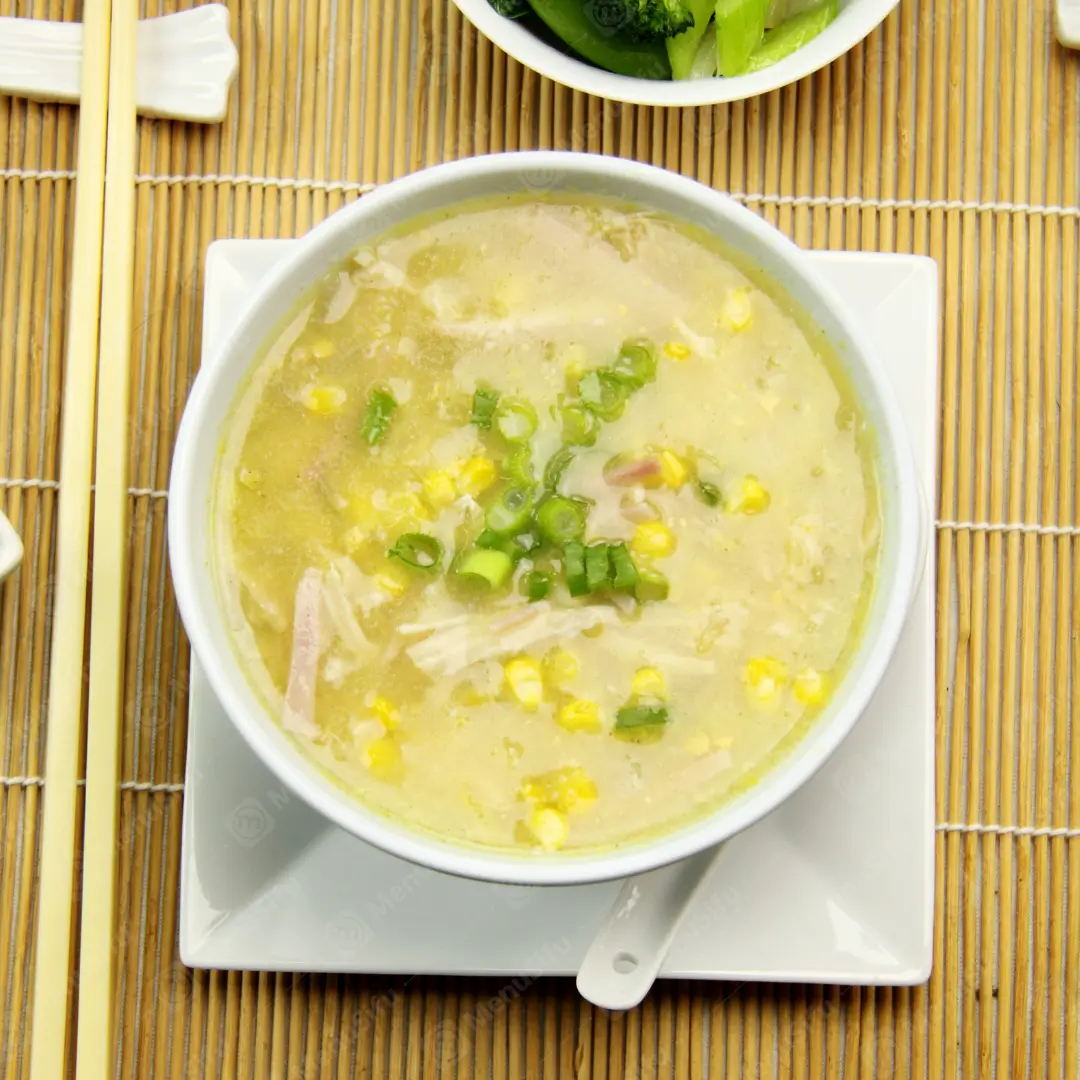 Chicken Rcie Soup is a warm and savory soup made with chicken, corn kernels, and garnished with chopped scallions, offering a rich and comforting taste.
